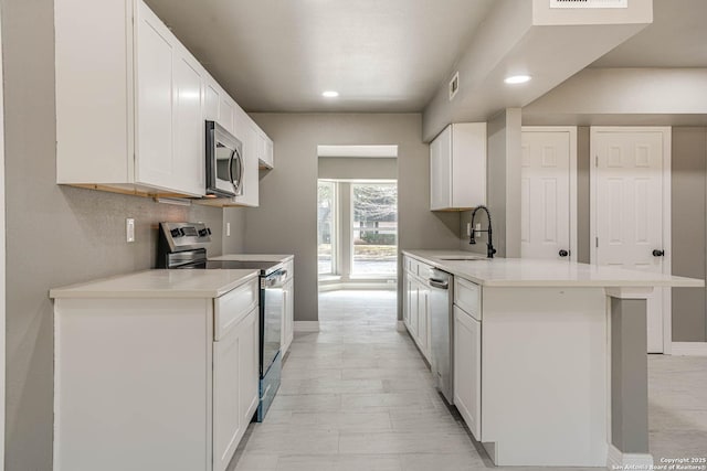 kitchen featuring appliances with stainless steel finishes, sink, and white cabinets