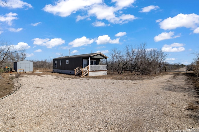 view of front of property featuring a storage unit and covered porch