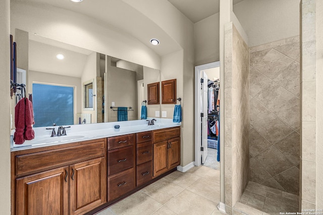 bathroom featuring vanity, tile patterned flooring, and a tile shower