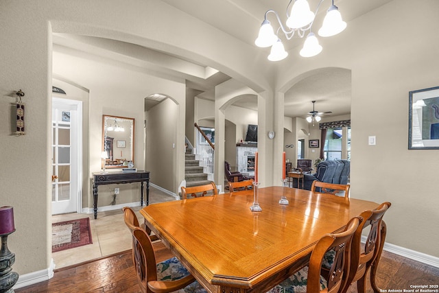 dining space with hardwood / wood-style floors and ceiling fan with notable chandelier