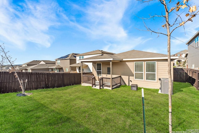 rear view of house featuring a yard and central AC