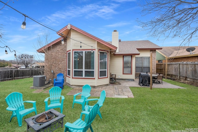 rear view of property with central AC, an outdoor fire pit, a yard, and a patio area