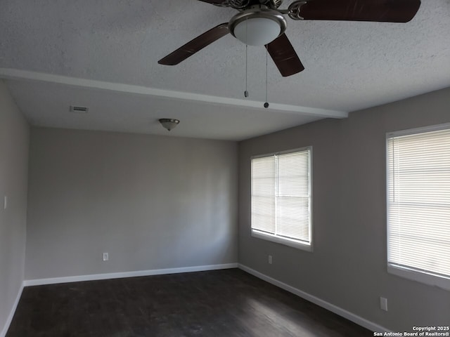 unfurnished room featuring ceiling fan, plenty of natural light, dark hardwood / wood-style floors, and a textured ceiling