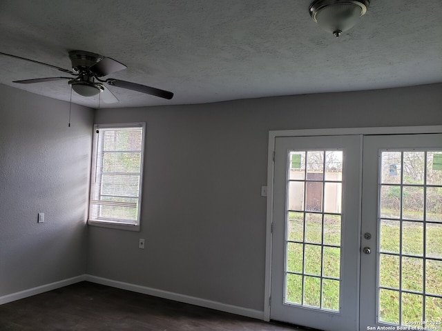 empty room featuring french doors and a textured ceiling