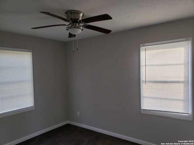 empty room with dark wood-type flooring and ceiling fan