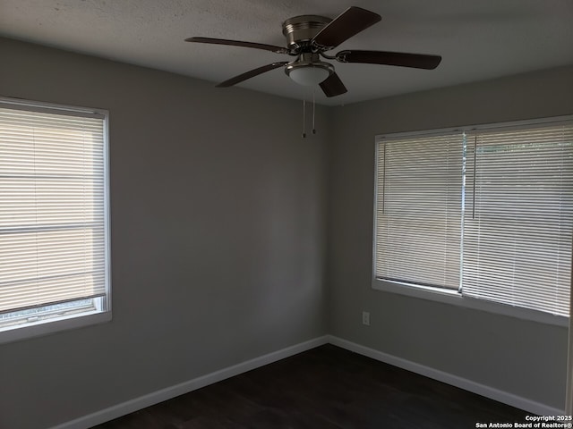 spare room with dark wood-type flooring and ceiling fan