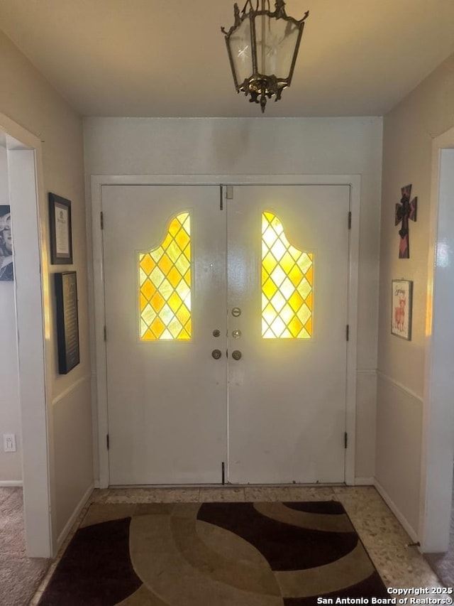 entryway featuring french doors and a chandelier