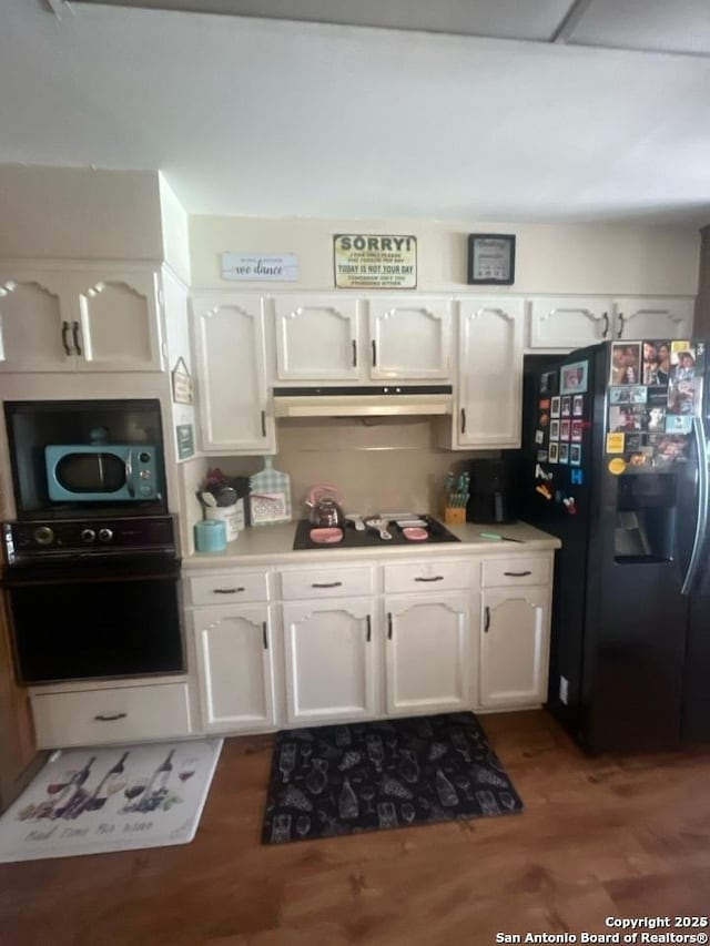 kitchen with dark hardwood / wood-style flooring, black appliances, and white cabinets