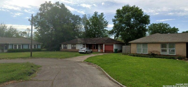 ranch-style house with a garage and a front lawn