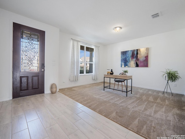 entryway featuring light colored carpet