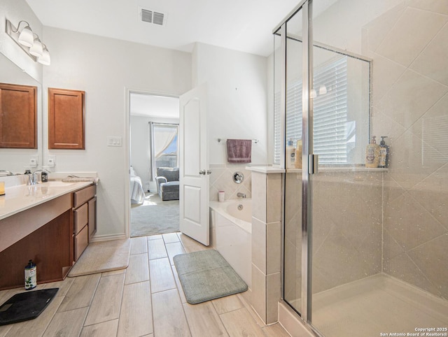 bathroom featuring vanity and separate shower and tub