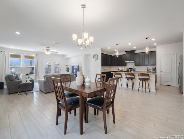 dining area with ceiling fan with notable chandelier