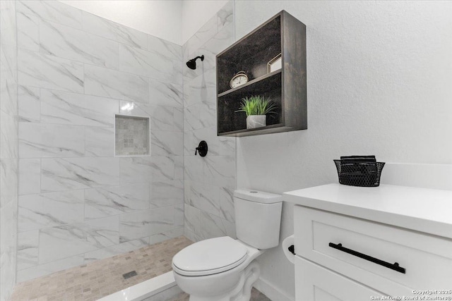 bathroom featuring tiled shower and toilet