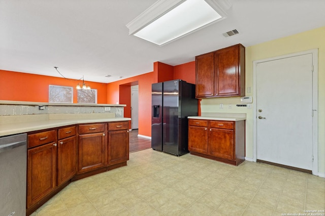 kitchen featuring pendant lighting, stainless steel appliances, and a chandelier