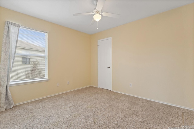 carpeted spare room featuring ceiling fan