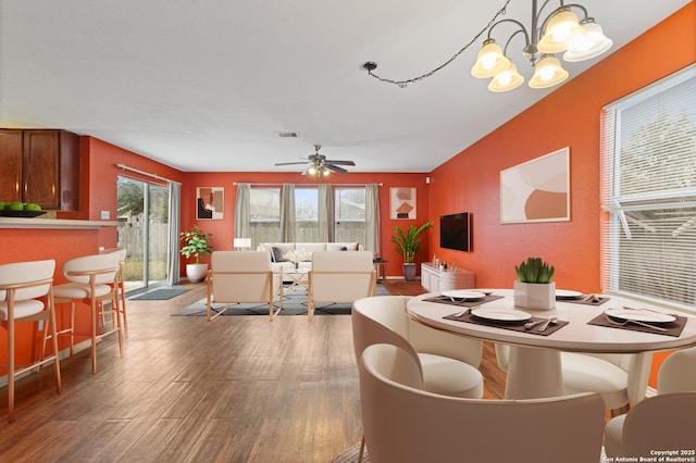 dining room featuring hardwood / wood-style flooring and ceiling fan with notable chandelier