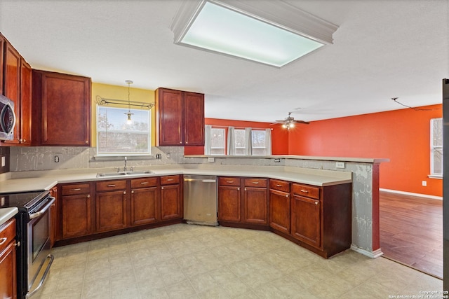 kitchen featuring sink, appliances with stainless steel finishes, hanging light fixtures, backsplash, and kitchen peninsula