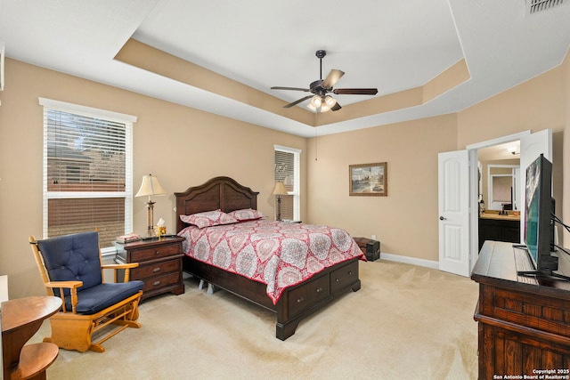 carpeted bedroom featuring a raised ceiling and ceiling fan