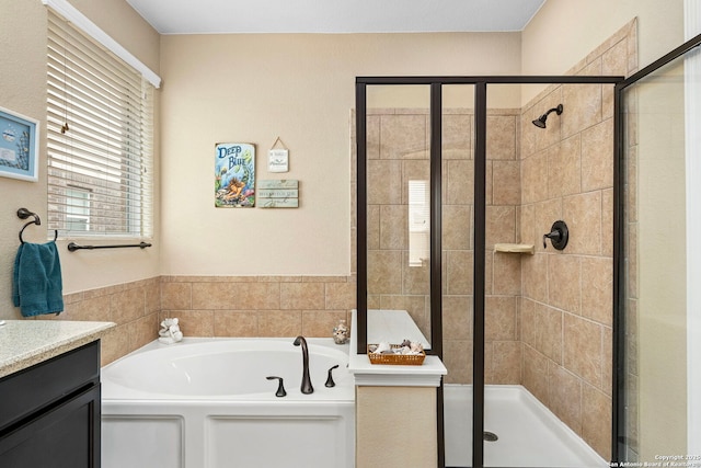 bathroom with vanity and shower with separate bathtub