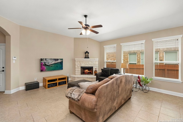 tiled living room featuring ceiling fan, vaulted ceiling, and a fireplace