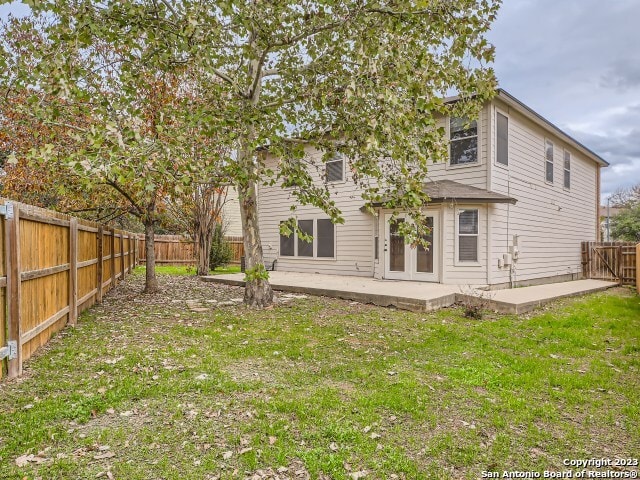 rear view of house featuring a patio and a yard