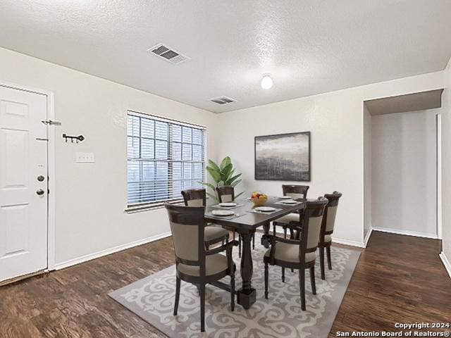 dining area featuring dark hardwood / wood-style floors and a textured ceiling