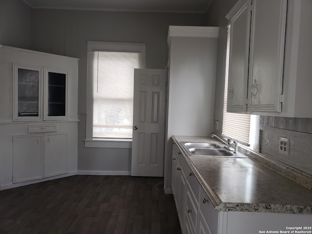 kitchen featuring backsplash, dark hardwood / wood-style flooring, sink, and white cabinets