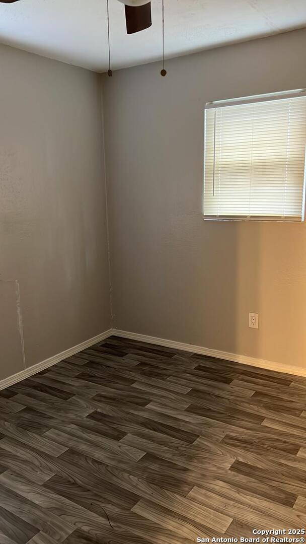 empty room featuring ceiling fan and dark hardwood / wood-style flooring