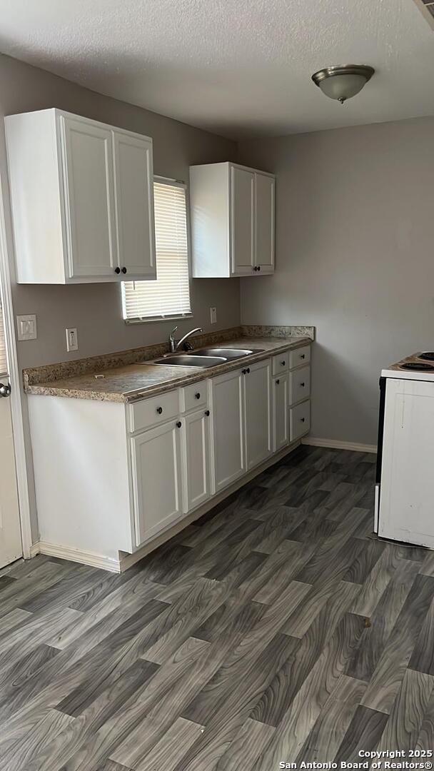 kitchen featuring white cabinetry, sink, dark hardwood / wood-style floors, and white electric range oven