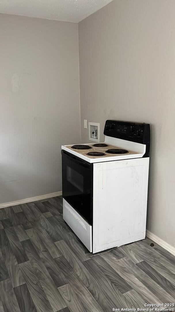 kitchen featuring electric stove and dark wood-type flooring