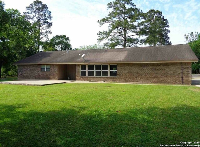 back of house featuring a lawn and a patio