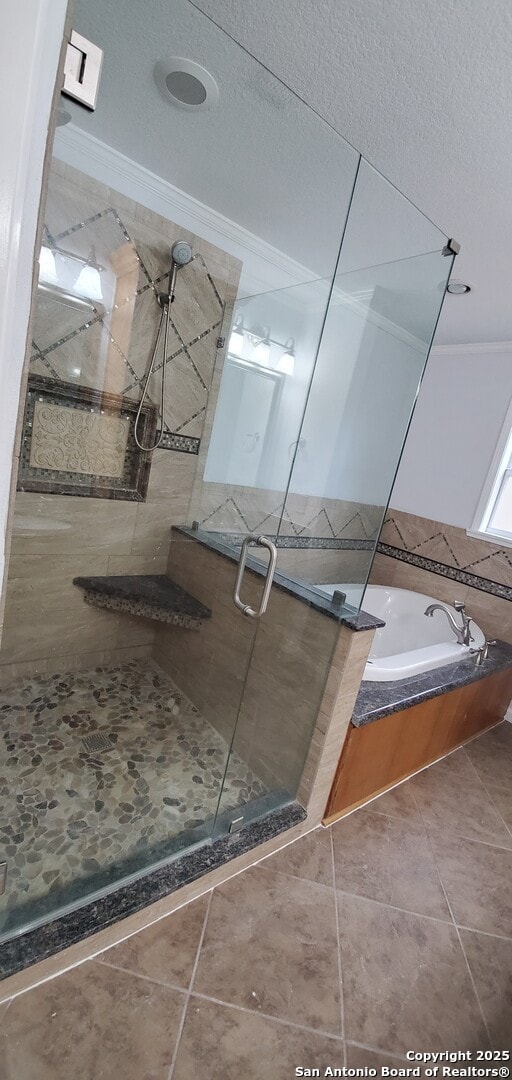 bathroom featuring shower with separate bathtub, a textured ceiling, tile patterned floors, and crown molding