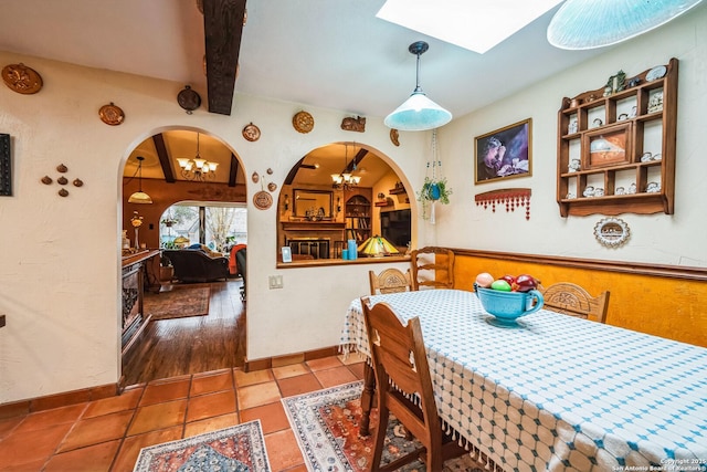 dining area with beamed ceiling, tile patterned flooring, and a notable chandelier