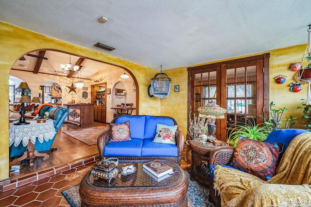 tiled living room with an inviting chandelier and a textured ceiling