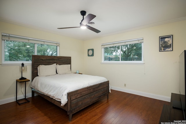 bedroom with multiple windows, dark hardwood / wood-style flooring, and ornamental molding