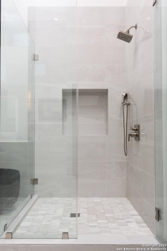 bathroom with a shower with door