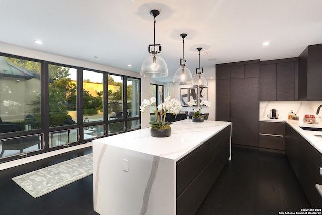 kitchen featuring sink, hanging light fixtures, dark hardwood / wood-style floors, and a center island