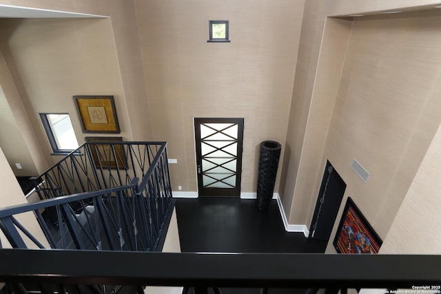 stairs with hardwood / wood-style flooring and a towering ceiling