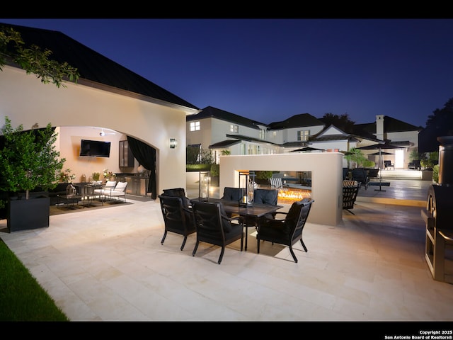 patio at night featuring exterior kitchen