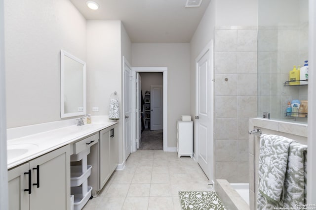 bathroom with tile patterned flooring, vanity, and tiled shower