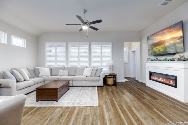 living room featuring vaulted ceiling, ceiling fan, and light wood-type flooring