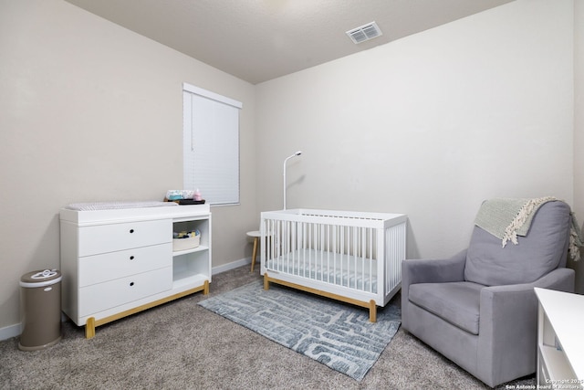 carpeted bedroom with a nursery area