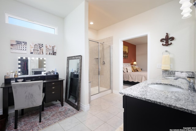 bathroom with a shower with door, vanity, and tile patterned floors