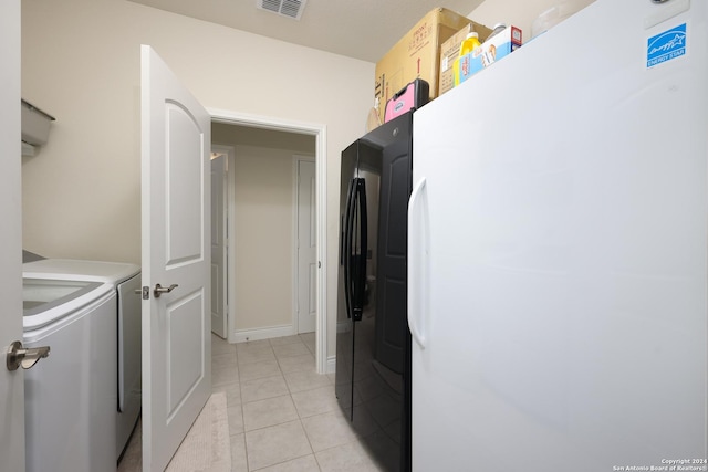 laundry area featuring light tile patterned floors and independent washer and dryer