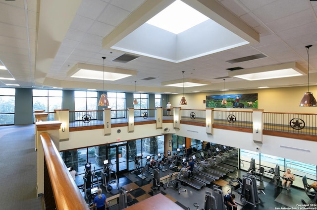 exercise room with a paneled ceiling and a raised ceiling