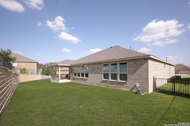 rear view of house with a yard