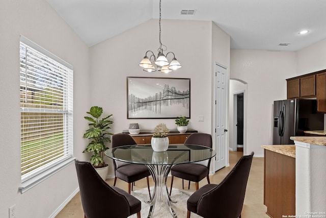 dining area with an inviting chandelier and lofted ceiling