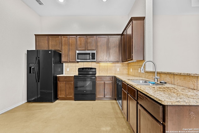 kitchen with light stone countertops, sink, backsplash, and black appliances