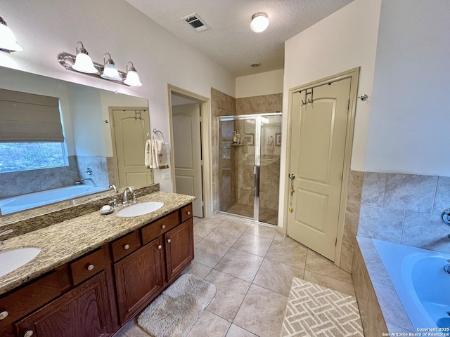 bathroom with vanity, tile patterned floors, a textured ceiling, and plus walk in shower