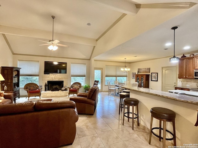 tiled living room featuring lofted ceiling with beams, ornamental molding, a stone fireplace, and a healthy amount of sunlight